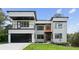 Modern two-story home with a black garage door, white facade and landscaped yard, exuding contemporary elegance at 1610 Niskey Lake Sw Rd, Atlanta, GA 30331