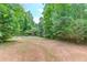 Picture of the backyard highlighting spacious lawn with tall trees and a fence at 322 Kibbee Rd, Mcdonough, GA 30252