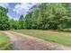 Picture of the land on a sunny day with a long gravel road leading through trees at 322 Kibbee Rd, Mcdonough, GA 30252