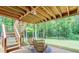 Backyard patio under screened in porch with seating and stairs to yard at 322 Kibbee Rd, Mcdonough, GA 30252