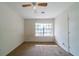 Bright bedroom with a ceiling fan and a large window, creating a light-filled space and carpeted floors at 5255 Biffle Downs Rd, Stone Mountain, GA 30088