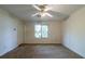 Spacious bedroom with a ceiling fan, neutral carpet, and a large window at 5255 Biffle Downs Rd, Stone Mountain, GA 30088