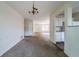 Open-concept living space with view into kitchen, carpeted floors, and chandelier, perfect for modern living at 5255 Biffle Downs Rd, Stone Mountain, GA 30088