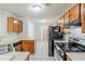 Functional kitchen with tile floors, black appliances, and oak cabinets at 870 Chapman Cir, Stone Mountain, GA 30088