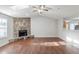 Large living room with a stone fireplace, ceiling fan, and wood floors at 870 Chapman Cir, Stone Mountain, GA 30088