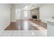 Open-concept view from dining area to living room with stone fireplace and wood floors at 870 Chapman Cir, Stone Mountain, GA 30088