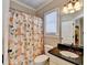 Bathroom features shower with a peach and green patterned curtain, as well as a granite countertop at 2505 Weber Heights Way, Buford, GA 30519