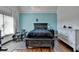 Bedroom with light blue accent wall, exercise equipment, and hardwood floors at 2505 Weber Heights Way, Buford, GA 30519