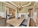 Light-filled dining room with wainscoting, a tray ceiling, and a view into adjacent rooms at 2505 Weber Heights Way, Buford, GA 30519