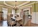 A dining room with a chandelier, wainscoting, and ample seating space for entertaining guests at 2505 Weber Heights Way, Buford, GA 30519
