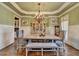 Elegant dining room with wainscoting, chandelier, and a table set for six, exuding sophistication at 2505 Weber Heights Way, Buford, GA 30519