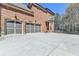 Spacious three car garage with ample driveway space and a brick home exterior at 2505 Weber Heights Way, Buford, GA 30519