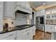 Elegant kitchen featuring white cabinetry, stainless steel appliances, granite countertops, and hardwood floors at 2505 Weber Heights Way, Buford, GA 30519