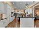 Open kitchen with white cabinetry, granite countertops, island seating, and modern appliances at 2505 Weber Heights Way, Buford, GA 30519