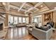 Spacious living room with a stone fireplace, hardwood floors, coffered ceiling, and large windows at 2505 Weber Heights Way, Buford, GA 30519