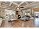 Open-concept living room with hardwood floors, coffered ceilings, and seamless flow to the kitchen at 2505 Weber Heights Way, Buford, GA 30519