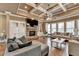Cozy living room featuring a stone fireplace, built-in cabinets, coffered ceiling, and large windows at 2505 Weber Heights Way, Buford, GA 30519