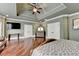 Spacious primary suite with hardwood floors, large windows, tray ceilings, and a TV at 2505 Weber Heights Way, Buford, GA 30519