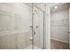 Modern tiled shower featuring a glass door and a convenient built-in niche, complemented by an adjacent walk-in closet at 2770 Aralynn Way, College Park, GA 30337