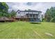 Exterior view of house showcasing the backyard, deck, sunroom, and trampoline at 3442 Inns Brook Way, Snellville, GA 30039