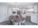Spacious kitchen and dining area with white cabinets, stainless steel appliances, and modern lighting at 3442 Inns Brook Way, Snellville, GA 30039