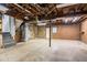 Unfinished basement with concrete floor and exposed rafters at 477 Victoria Rd, Woodstock, GA 30189