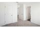 Hallway with neutral carpet and multiple white doors at 360 White Tail Rd, Stockbridge, GA 30253
