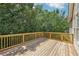 Large wooden back deck with railings overlooking lush greenery, perfect for outdoor relaxation and entertainment at 1780 Riverglen Dr, Suwanee, GA 30024