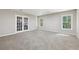 Spacious basement featuring plush carpeting, natural light, and double doors leading to the exterior at 1780 Riverglen Dr, Suwanee, GA 30024
