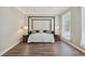 Neutral bedroom with hardwood floors, a four-poster bed, and side tables with lamps at 1780 Riverglen Dr, Suwanee, GA 30024