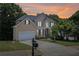 Beautiful two-story home with a well-manicured lawn and attached two-car garage at sunset at 1780 Riverglen Dr, Suwanee, GA 30024