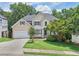 Charming two-story home with manicured lawn, attached garage, and mature trees providing shade and curb appeal at 1780 Riverglen Dr, Suwanee, GA 30024