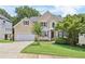 Charming two-story traditional home with tan siding, an attached garage and a well-manicured lawn at 1780 Riverglen Dr, Suwanee, GA 30024
