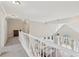 Second floor hallway with white railing overlooking open-concept living space below at 1780 Riverglen Dr, Suwanee, GA 30024