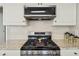 Updated kitchen featuring stainless steel gas range, granite countertops, subway tile backsplash, and white cabinets at 1780 Riverglen Dr, Suwanee, GA 30024