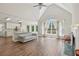 Bright living room featuring a vaulted ceiling, large windows, fireplace, and view into an open kitchen area at 1780 Riverglen Dr, Suwanee, GA 30024