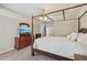 Main bedroom with canopy bed, tray ceiling, dresser, and television at 1780 Riverglen Dr, Suwanee, GA 30024