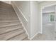 Carpeted staircase leading to finished basement with ceiling tiles and a window at 1780 Riverglen Dr, Suwanee, GA 30024