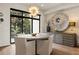 Dining area with modern light fixture and a view of lush exterior greenery from expansive windows at 904 Lenox Ne Blvd, Atlanta, GA 30324