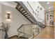 Contemporary staircase with glass railings and wood steps, lit by modern sconces at 904 Lenox Ne Blvd, Atlanta, GA 30324