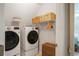 This laundry room has a washer, a dryer, and some shelves at 1835 Berkeley Ne Mews, Atlanta, GA 30329