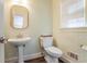Charming powder room showcasing patterned wallpaper, pedestal sink, and a window offering natural light at 1835 Berkeley Ne Mews, Atlanta, GA 30329
