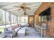 Cozy screened-in porch with ceiling fans, brick wall, and a view of the wooded backyard at 1835 Berkeley Ne Mews, Atlanta, GA 30329
