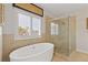 Bright bathroom featuring a soaking tub, walk-in shower and tan tiling at 340 Marietta Walk Ln, Marietta, GA 30064
