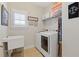 Laundry room featuring a utility sink, washer and dryer, and storage shelves at 340 Marietta Walk Ln, Marietta, GA 30064