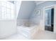 Bright bathroom features a large tub, tile floors, and marble walls, and a window at 468 W Paces Ferry Rd, Atlanta, GA 30305
