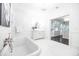 Light-filled bathroom featuring a luxurious soaking tub and a view into the walk-in closet at 468 W Paces Ferry Rd, Atlanta, GA 30305
