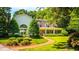 Charming white home surrounded by lush greenery, featuring a brick path and a covered front porch at 468 W Paces Ferry Rd, Atlanta, GA 30305
