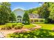 Stunning exterior view of a white home with a brick walkway, lush landscaping, and a welcoming front porch at 468 W Paces Ferry Rd, Atlanta, GA 30305