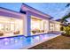 Twilight view of a modern home with a beautiful pool, outdoor kitchen, and covered patio at 0 Ebenezer Rd, Fayetteville, GA 30215